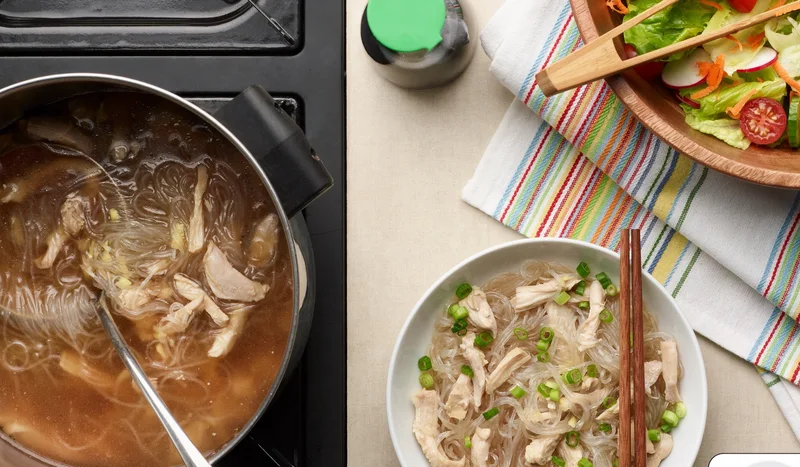 Chicken long rice in a pot and a serving bowl.
