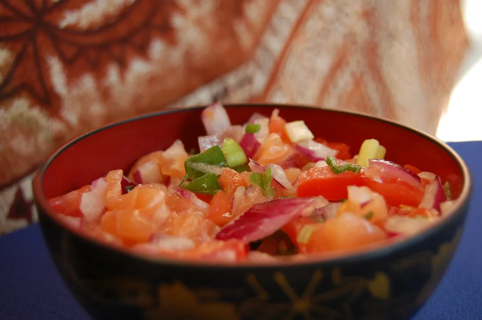 Diced salmon, tomatoes, red onion, and green onion mixed in a bowl.