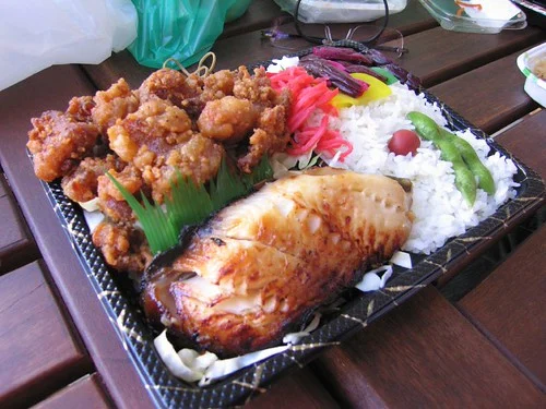 Mochiko chicken at the upper left of a bento with butterfish and rice.